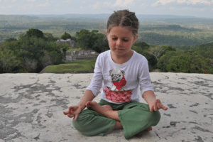 A tween girl meditating in Belize. Phot by: harmoniouskids.com